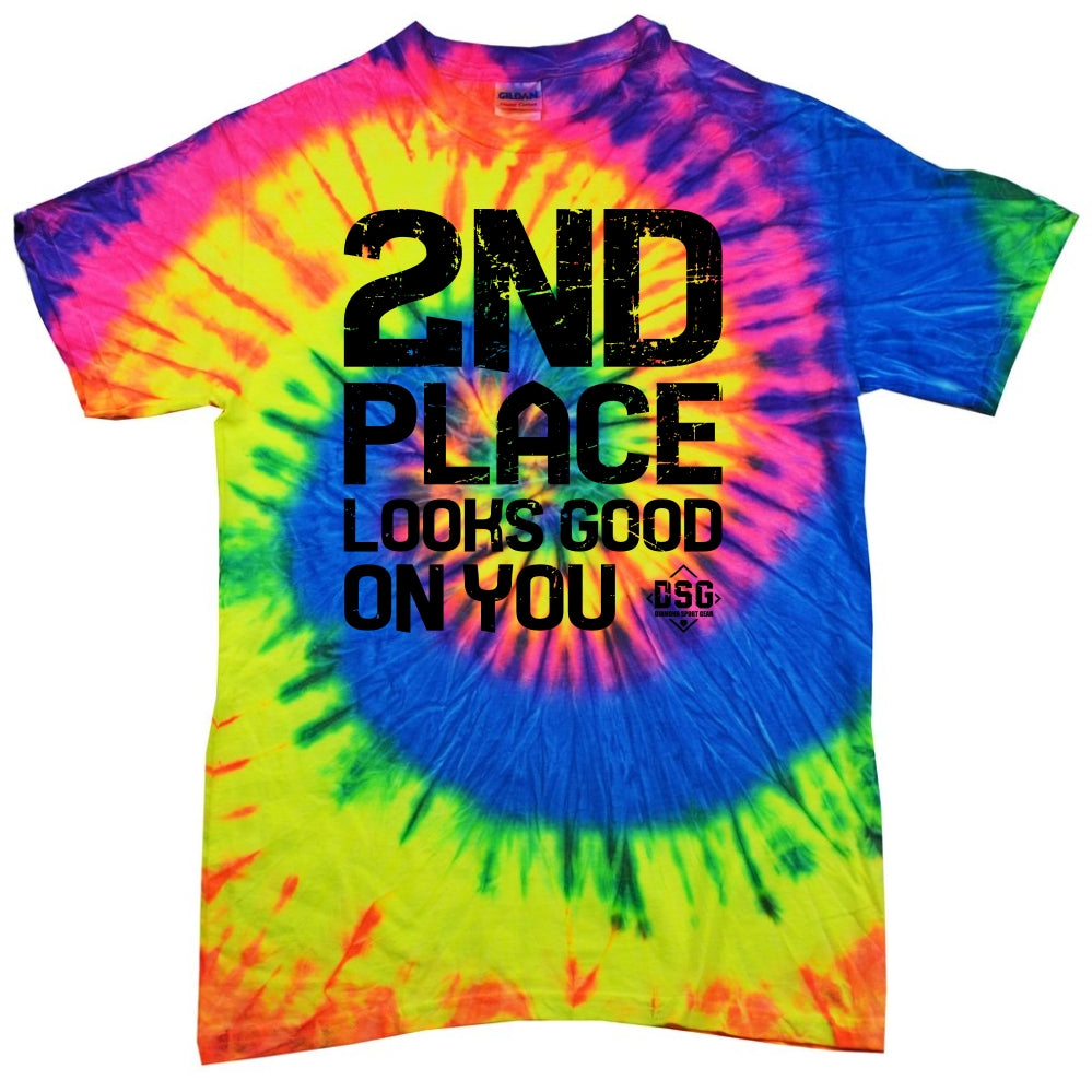 The DSG Apparel 2nd Place Looks Good on You T-Shirt features a vibrant yellow, blue, pink, and green tie dye spiral pattern on pre-shrunk cotton with a classic fit and bold black "2ND PLACE LOOKS GOOD ON YOU" text on the front.
