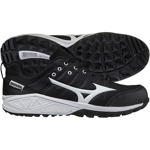 A pair of Mizuno Ambition 2 All Surface Low Men's Turf Shoes 320632 in black with white soles and side logos, designed for superior traction; one shoe is shown from the side, the other displays the textured sole.