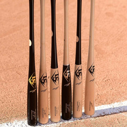 Five Louisville Slugger MLB Prime Signature Series CY22 Christian Yelich Game Model wood bats (WBL2435010) stand vertically together on the field, leaning on the dirt near a white chalk baseline.