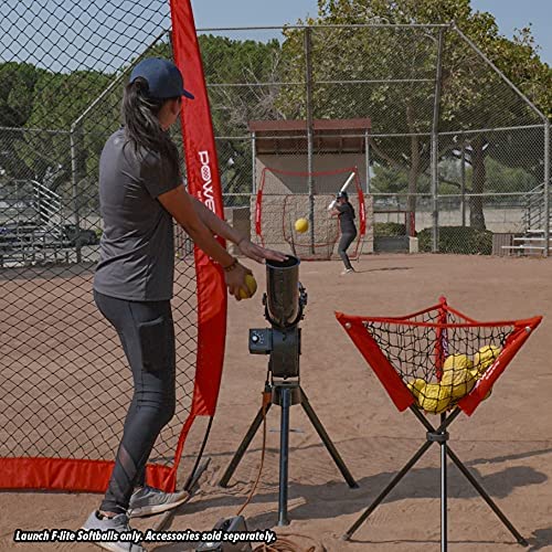 A woman hits a practice softball with a PowerNet Launch F-Lite Pitching Machine Fastpitch Softball (1194-2), using pitching machine balls that match regulation softball size.