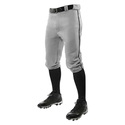 A person wears Champro Sports’ Triple Crown Knicker Baseball Pants with Piping (BP101A) in gray, paired with a black belt, black knee-high socks, and black cleats, shown waist down against a white background.