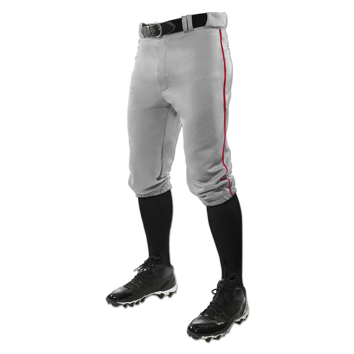 A person wears Champro Sports Adult Triple Crown Knicker Baseball Pants with red piping (BP101A), made of gray pro-weight fabric, paired with a black belt, knee-high black socks, and black cleats; only the lower body is shown.
