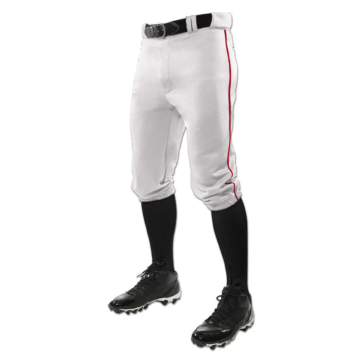 A person waist down in Champro Sports Youth Triple Crown Knicker Baseball Pants with red piping (BP101Y), a black belt, black knee-high socks, and black cleats, shown against a white background.