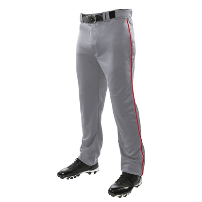 A person wears Champro Sports Triple Crown Open Bottom Baseball Pants with red piping (BP91UA), paired with a black belt and black cleats. The photo shows only their lower body, waist down.