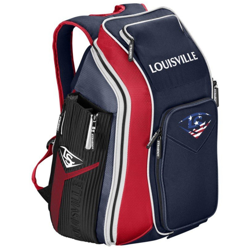 The Louisville Slugger Prime Stick Pack Backpack (WTL9902) in navy blue, red, and white features multiple zippered compartments, the Louisville Slugger logo, and a front pocket with an American flag baseball graphic.