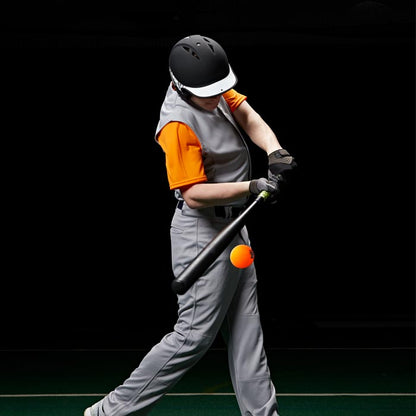 A baseball player in a gray uniform and black helmet hits a Champro Sports 9" Control Flight Hitting Ball (CBB92) with a black bat against a dark background.