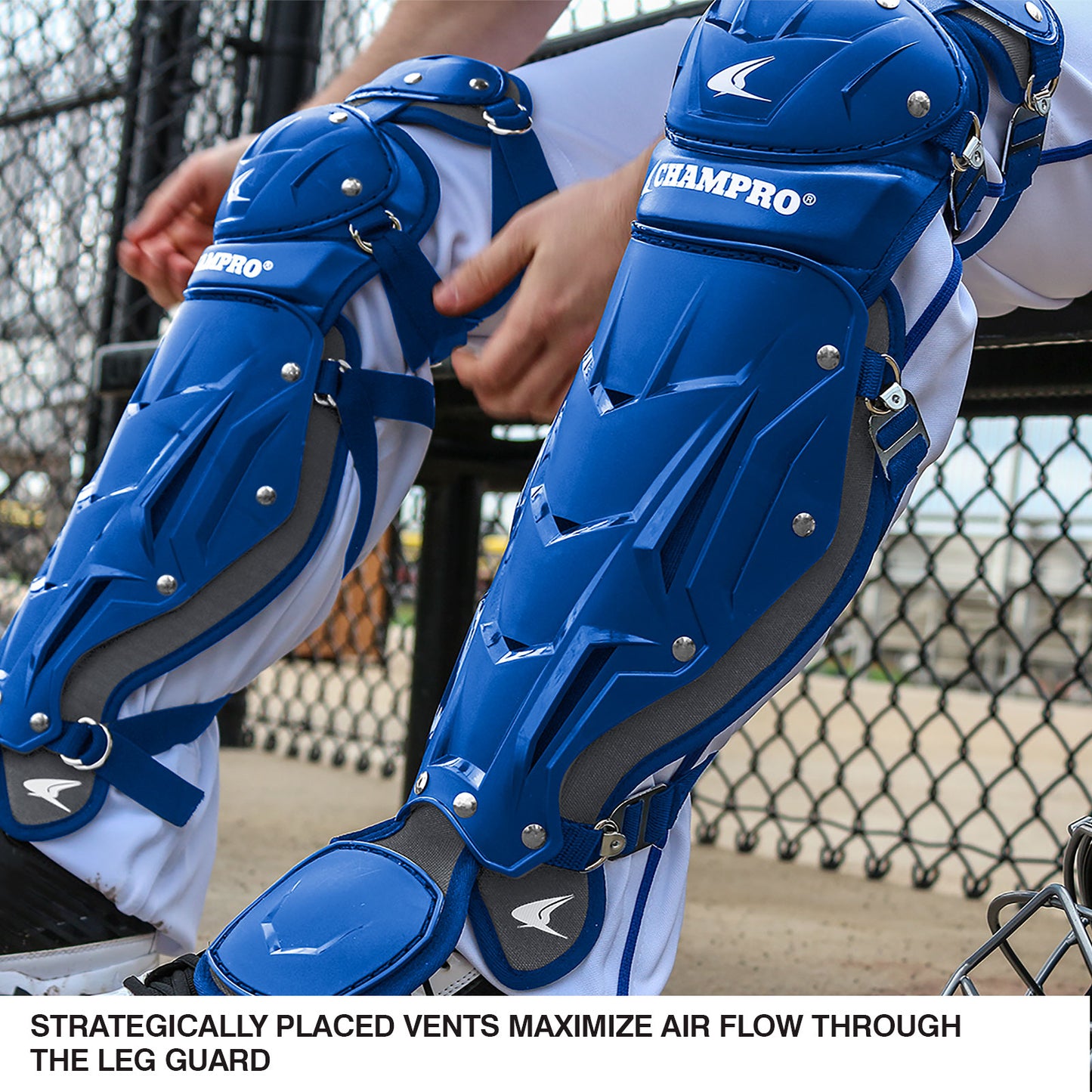 A close-up of Champro Sports Optimus Pro Catcher’s Leg Guards: CG18, featuring blue vents for airflow and moisture wicking, worn by a player behind a chain-link fence. Text reads: Strategically placed vents maximize air flow.