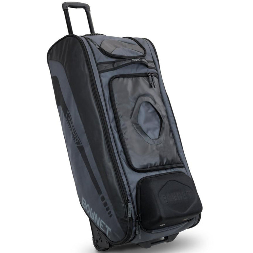 The Bownet Commander Wheeled Catcher's Bag (BN-COMMANDER BAG) features a black and gray design, telescoping handle, side pocket, top compartment, front window panel, and stands upright on wheels.