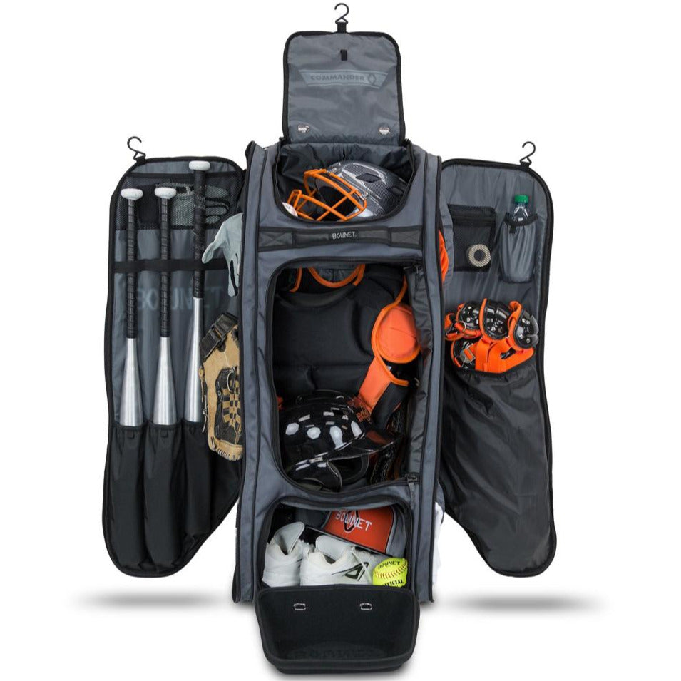 The Bownet Commander Wheeled Catcher's Bag (BN-COMMANDER BAG) by Bownet opens to reveal compartments for bats, gloves, helmets, cleats, softballs, a water bottle, and other essential baseball or softball gear.
