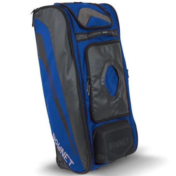 The Bownet Commander Wheeled Catcher's Bag (BN-COMMANDER BAG) is a large blue and black equipment bag with multiple zippered compartments, "BOWNET" printed on the side, reinforced handles, wheels, and an upright design for easy transport.