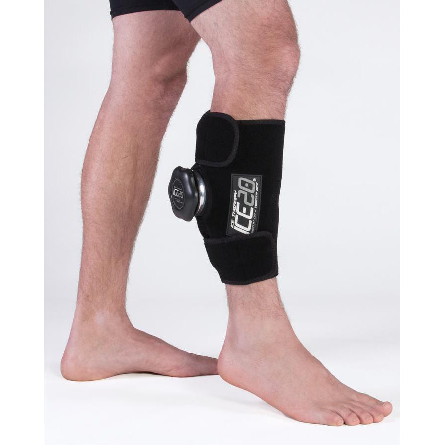 A person stands barefoot on a white background wearing the Bownet ICE20 Elbow / Small Knee Ice Compression Wrap (ICE-ELBOW-SM KNEE) on their lower leg, just below the knee.