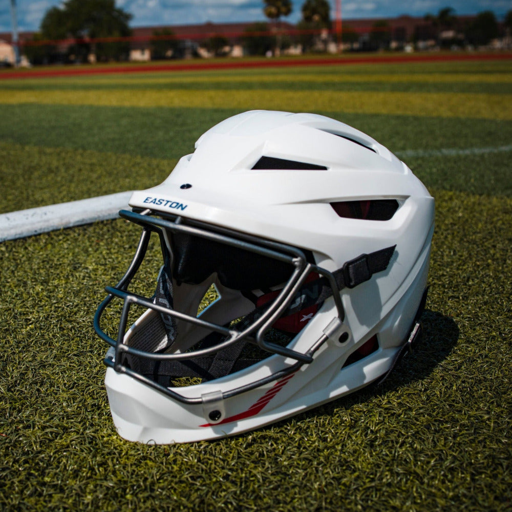 An Easton Hellcat Slowpitch Fielding Helmet (EHCATH) by Easton sits on the field, exemplifying top-tier protective gear for all players.