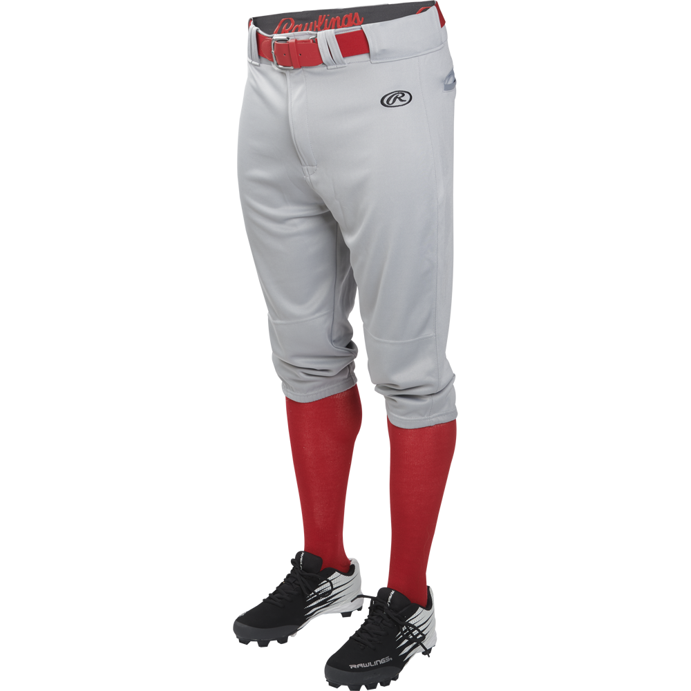 Rawlings Youth Launch Knicker Baseball Pants (YLNCHKP) in gray, paired with a red belt, red socks, and black cleats. The cropped fit highlights the socks and features the Rawlings logo on the waistband.