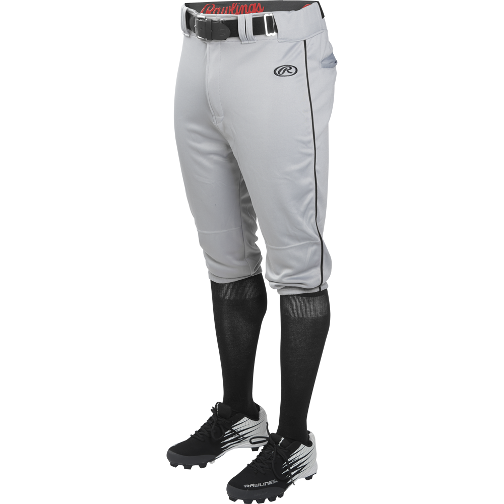A person wears Rawlings Adult Launch Knicker Baseball Pants with black piping in Blue Grey/Black, featuring the Rawlings logo on the left thigh, paired with a black belt, black knee-high socks, and black cleats with white accents.