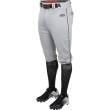 A person wears Rawlings Youth Launch Knicker Baseball Pants with Piping (gray with black piping), plus a black belt, black knee-high socks, and black cleats, shown waist down against a plain background.