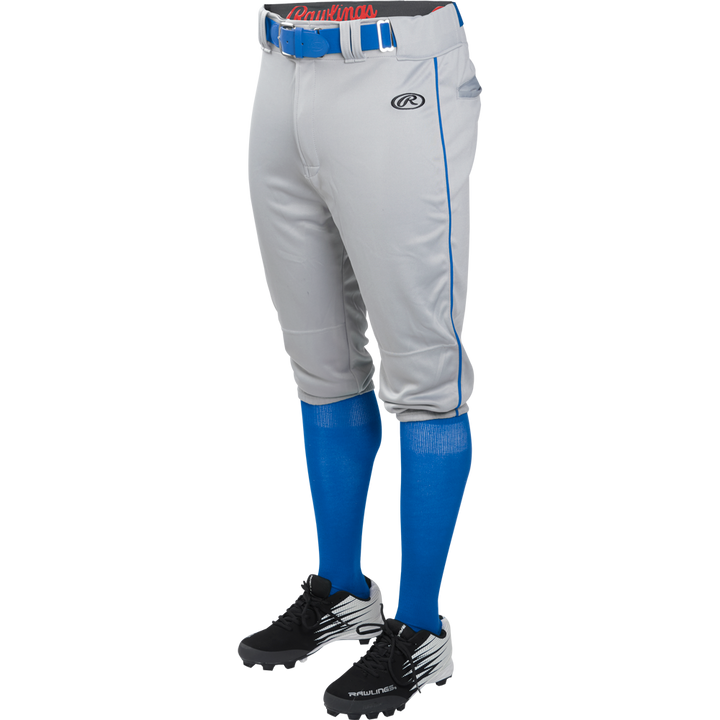 Someone wearing Rawlings Adult Launch Knicker Baseball Pants (Blue Grey/Royal) with blue piping, paired with a blue belt, blue high socks, and black and white cleats. The upper body is not visible.
