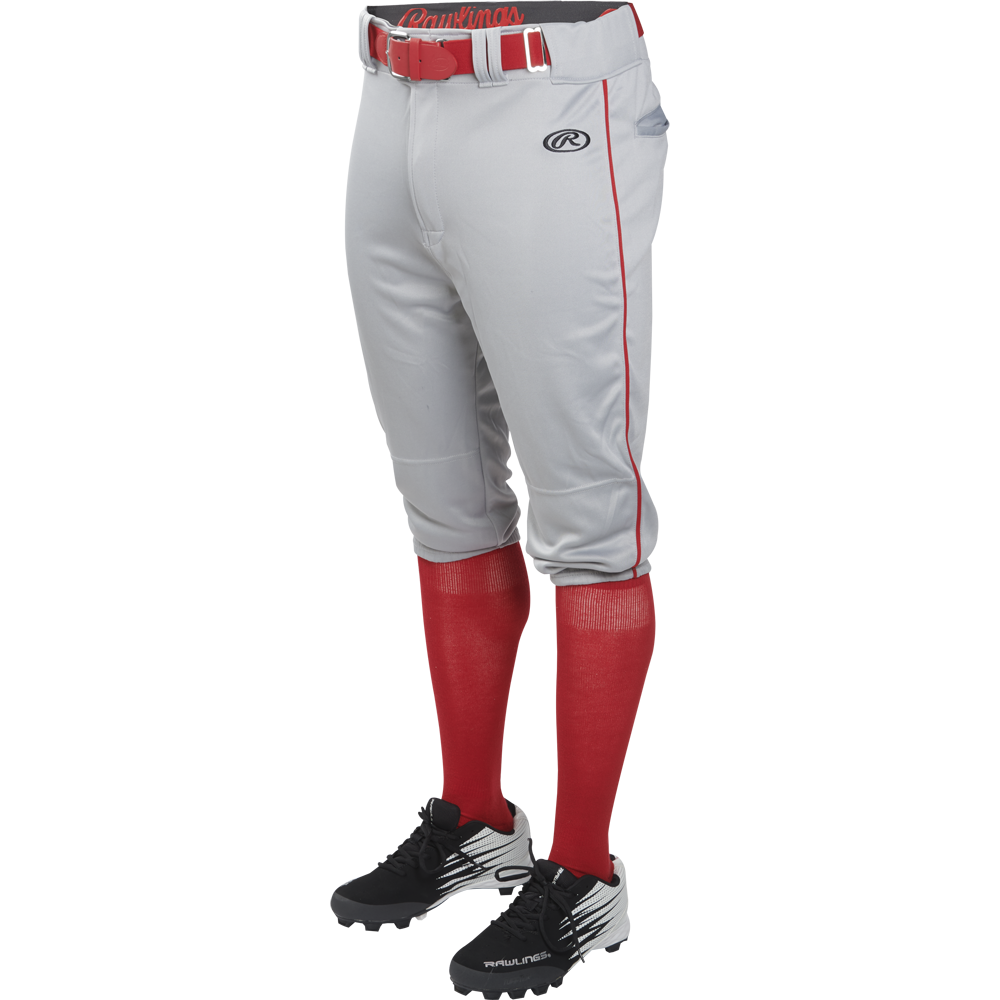 A person is wearing Rawlings Adult Launch Knicker Baseball Pants with Piping (Blue Grey/Scarlet), featuring red piping, a red belt, red knee-high socks, and black baseball cleats. The top half of the person is not visible.