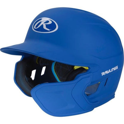 A blue Rawlings Mach Matte Batting Helmet with EXT Flap (MACHEXT) features protective ear and jaw guards, black interior padding, and a white Rawlings logo on the front and side.