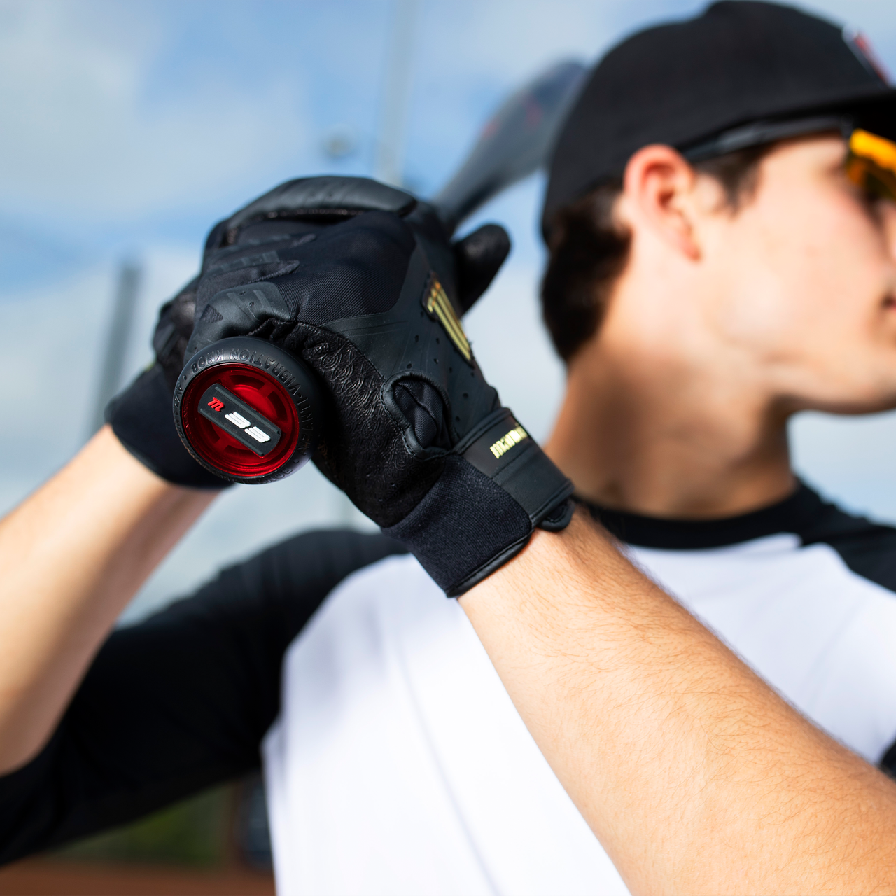A baseball player in black gloves and a cap grips the Marucci 2021 CAT9 (-8) 2 3/4" USSSA Baseball Bat (MSBC98) over his shoulder, focusing on his hands holding the one-piece alloy bat from Marucci.