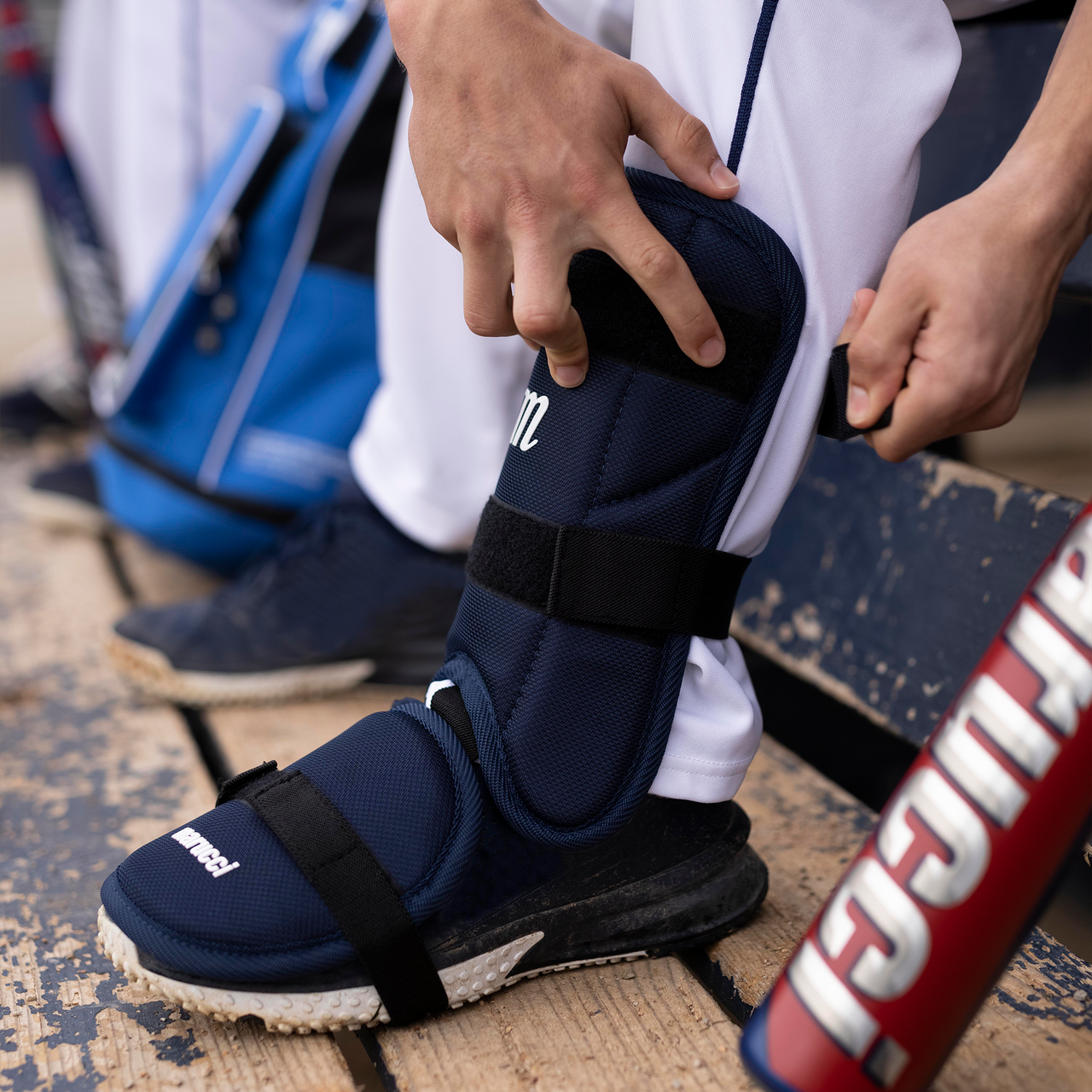 An individual wearing the Marucci Batter's Leg Guard: MPLG3, an adjustable shin guard by Marucci featuring extended ankle protection.
