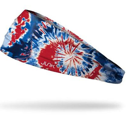 The Junk Pride Headband by Junk features a blue, red, and white tie-dye design, sweat-wicking technical t-shirt fabric, "JUNK" logo print, and is shown against a white background.
