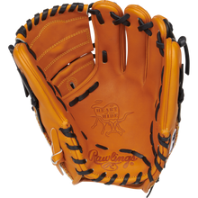 The Rawlings Heart of the Hide 11.75" Baseball Glove (PRO205-9TB) is a tan glove with black lacing and detailed stitching. Featuring open infield/pitcher's design, it displays Rawlings branding and a "Heart of the Hide" stamp on the palm.