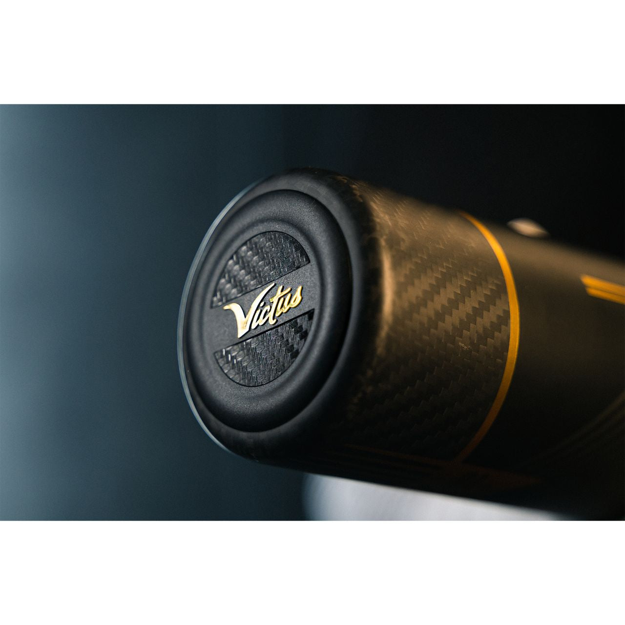 Close-up of the end cap on the 2022 Victus Vandal 2 (-8) USSSA Baseball Bat, featuring a carbon fiber texture and gold "Victus" script on black.