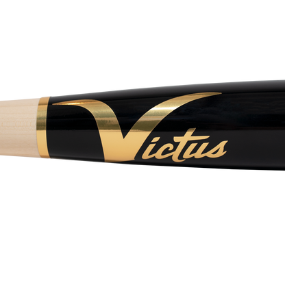 A close-up of the Victus TA7 Tim Anderson Pro Reserve Birch Wood Bat (VRWBTA7-NT/BK), featuring a black, end-loaded barrel, natural wood handle, gold Victus script logo, and large gold V—crafted with Big League-grade quality.