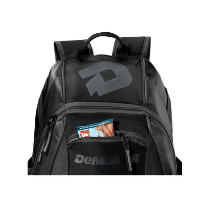 The DeMarini Voodoo Junior Backpack (WTD9106) features a large D logo on the top front and DeMarini branding on the pocket, with a zippered pocket ideal for snacks—perfect for young baseball players.
