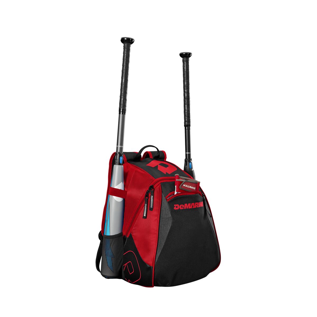 The DeMarini Voodoo Junior Backpack: WTD9106 in red and black stands upright, displaying two bats in its side sleeves, a blue water bottle in a mesh pocket, a visible front zipper, and the DeMarini logo.