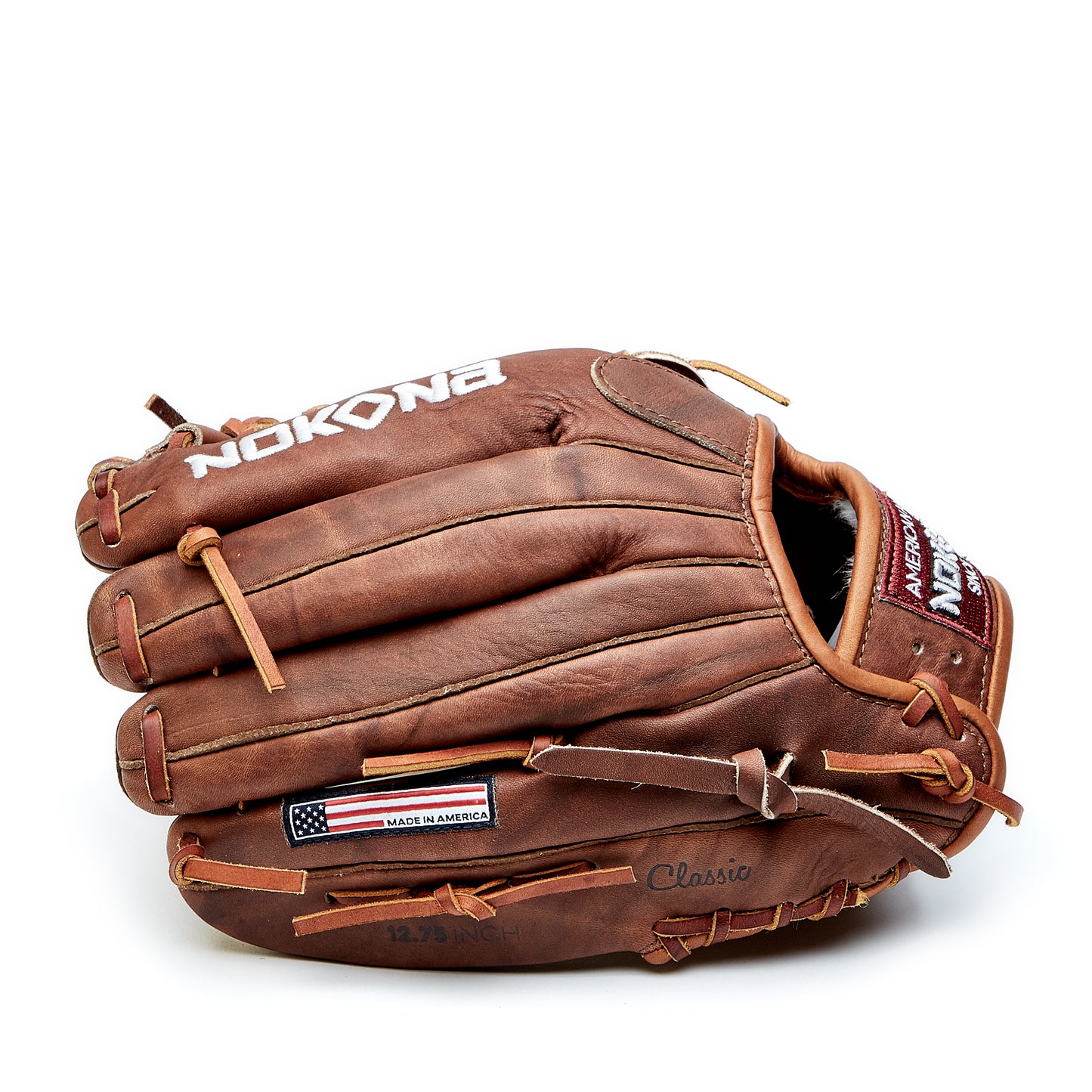 A Nokona Walnut 12.75" Baseball Glove (W-1275) made of brown leather features visible stitching, laces, a "Made in America" tag, and displays the Nokona brand name and Classic model on the side.