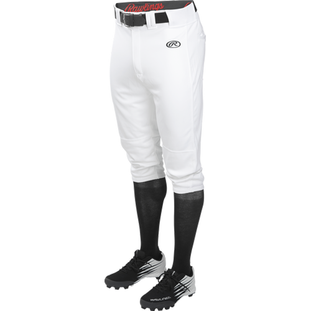 A person shown from waist to feet against a white background wears Rawlings Youth Launch Knicker Baseball Pants (YLNCHKP) with a black belt, black knee-high socks, and black baseball cleats.