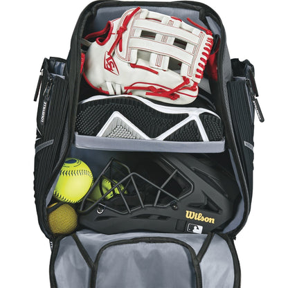 The Louisville Slugger Prime Stick Pack Backpack (WTL9902) by Louisville Slugger displays a baseball glove, cleats, helmet, and two yellow softballs neatly organized in its separate compartments.