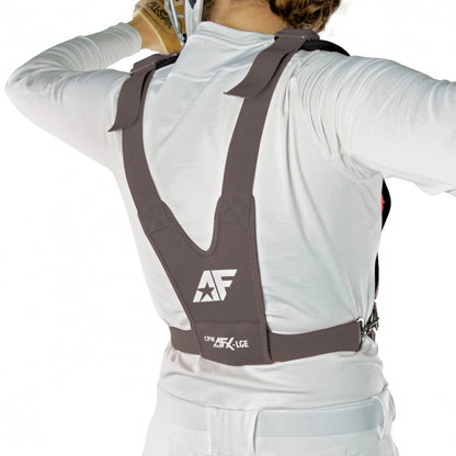 A person in white is shown from the back adjusting an All Star AFx Fastpitch Catcher's Chest Protector, CPW-AFX. This women's softball gear features thick shoulder straps and a wide torso strap for a secure fit.