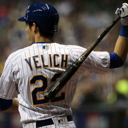 A player in a white pinstripe jersey with "YELICH" and 22 on the back stands on the field holding a Louisville Slugger MLB Prime Signature Series CY22 Christian Yelich Game Model Wood Baseball Bat (WBL2435010).