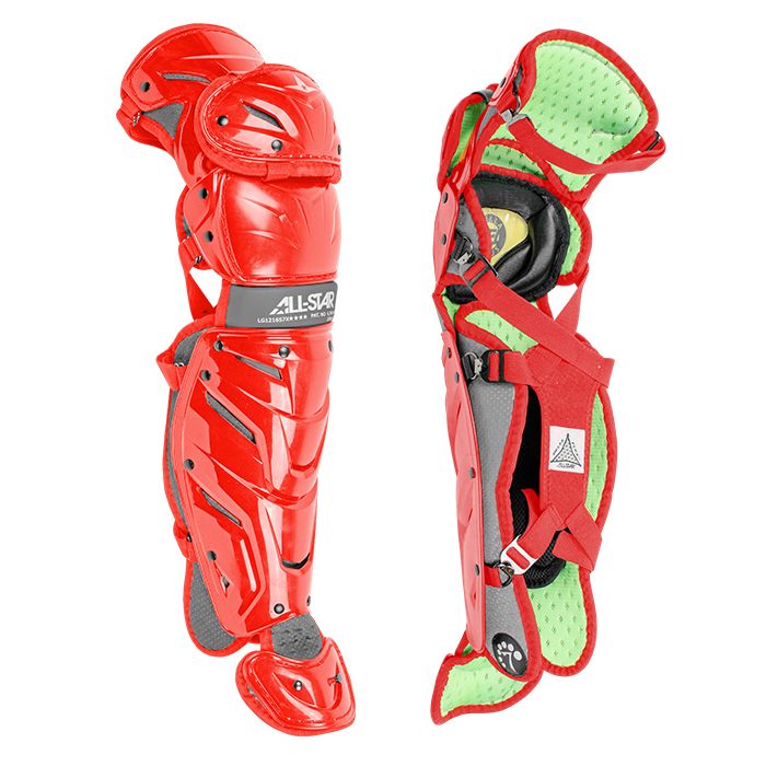 The All Star System7 Axis Catcher's Leg Guards are shown: one highlights the ALL-STAR branded hard shell, while the other reveals its green and red padded interior with adjustable straps and a flexible LINQ hinge system.