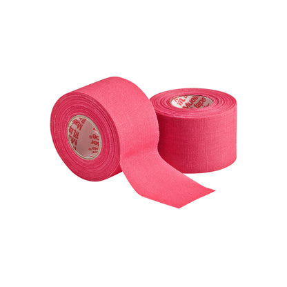 Two rolls of Mueller M Tape Athletic Tape (MTAPE) by Mueller—made with cotton backcloth, one upright with end unrolled, the other on its side—are shown against a white background. Perfect for sports medicine and injury support.