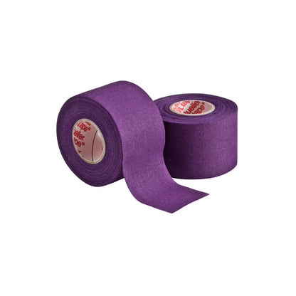 Two rolls of Mueller M Tape Athletic Tape (MTAPE) by Mueller are shown on a plain white background—one upright, one partially unrolled to display the textured cotton backcloth and inner label. The tape is purple.