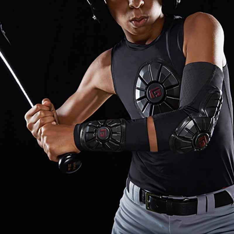 A baseball player in a helmet, sleeveless shirt, and G-Form Pro Wrist Guard (WG0102) grips a bat, preparing to swing against a black background.